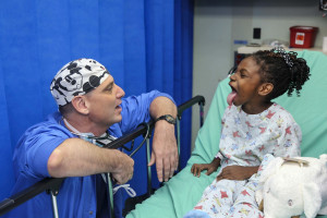 Doctor kneeing down beside a child " Pexels".