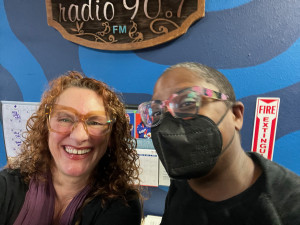 two women smile in the community radio lobby