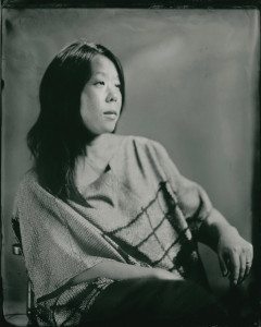 Black and white photo of a woman with dark hair sitting in a chair